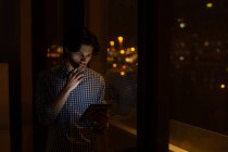 Männliche Führungskraft nutzt nachts digitales Tablet im Büro — Stockfoto