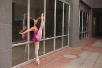 Vista lateral de bailarina urbana practicando danza en la ciudad . - foto de stock