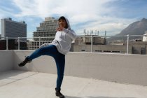 Beautiful casual woman dancing hip hop on terrace. — Stock Photo