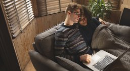 Casal usando laptop na sala de estar em casa — Fotografia de Stock