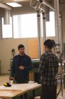 Zwei Handwerker interagieren in Werkstatt miteinander — Stockfoto