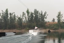 Mid adulte homme wakeboard dans l'eau de la rivière — Photo de stock