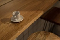 Крупный план пустой кофейной чашки на деревянном столе в кафе — стоковое фото