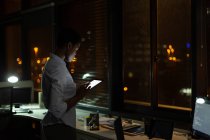 Женщина-руководитель с помощью цифрового планшета в офисе ночью — стоковое фото