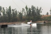 Metà uomo adulto wakeboarding in acqua di fiume — Foto stock
