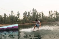 Homem adulto médio wakeboarding na água do rio — Fotografia de Stock