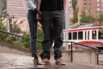 Low section of couple standing on pavement in city — Stock Photo
