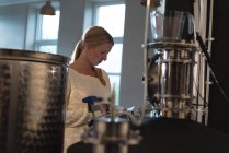 Блондинка-жіночий працівник використовує цифровий планшет на заводі пивоваріння — стокове фото