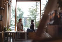 Casal olhando através da janela no interior do café — Fotografia de Stock