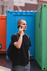 Primer plano del joven hablando por teléfono en la ciudad - foto de stock