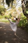 Aufmerksame städtische Balletttänzerin tanzt im Park. — Stockfoto