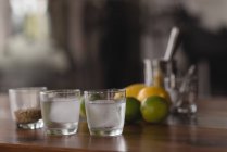 Primo piano di agrumi, grano e gin con ghiaccio nei bicchieri — Foto stock