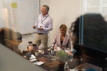 Executivo dando apresentação no quadro branco no escritório — Fotografia de Stock