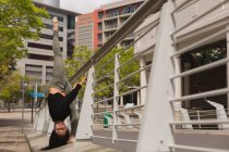 Bailarina urbana elegante practicando danza sobre barandilla de puente . - foto de stock