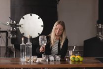 Travailleuse contrôlant la qualité du gin en usine — Photo de stock