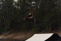 Молодой атлет вейкбординг в реке в сумерках — стоковое фото