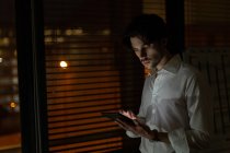 Чоловік виконавчий використовує цифровий планшет в офісі вночі — стокове фото