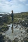 Femme rousse réfléchie debout dans la plage . — Photo de stock