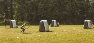 Чоловік і жінки практикують стрільбу з лука в таборі на сонячному світлі — стокове фото