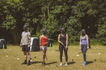 Grupo de pessoas treinando tiro com arco no acampamento de inicialização à luz do sol — Fotografia de Stock