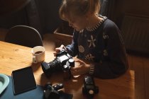 Donna che rivede le foto sulla fotocamera a casa — Foto stock