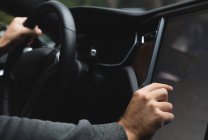 Close-up de homem usando mapa navegador durante a condução de um carro — Fotografia de Stock