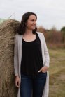 Donna appoggiata e posa su balle di fieno nel campo — Foto stock