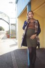 Mujer embarazada hablando por teléfono móvil en la plataforma en la estación de tren - foto de stock