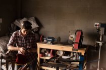 Metalsmith femminile utilizzando il telefono cellulare in fabbrica — Foto stock