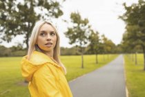 Femme blonde regardant loin dans le parc — Photo de stock