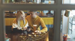 Giovane coppia discutendo sul cellulare nel ristorante — Foto stock