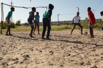 Bambini che giocano a calcio nel terreno in una giornata di sole — Foto stock