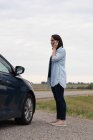 Vue latérale de la femme parlant sur le téléphone portable pendant la panne de voiture — Photo de stock