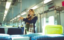 Vue latérale de la femme enceinte parlant sur mobile pendant qu'elle voyage en train — Photo de stock