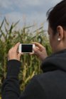 Крупним планом жінка натискає фотографії з камерою в полі — стокове фото