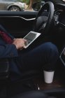Mittelteil des Geschäftsmannes mit digitalem Tablet im Auto — Stockfoto