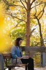 Woman using laptop in the park on a sunny day — Stock Photo
