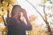 Женщина щёлкает фотографиями с камерой в солнечный день — стоковое фото