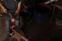 Section basse de fer à cheval de moulage de forgeron femelle dans l'usine — Photo de stock
