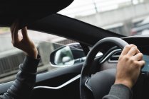 Крупный план человека, регулирующего зеркало заднего вида во время вождения автомобиля — стоковое фото