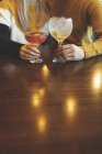 Section du milieu du couple tenant verre à cocktail dans le restaurant — Photo de stock
