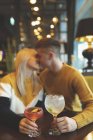 Casal beijando e segurando copo de coquetel no restaurante — Fotografia de Stock