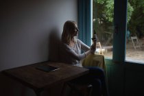Красива жінка використовує мобільний телефон вдома — стокове фото