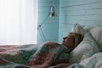 Красива жінка, що спить у спальні будинку — стокове фото