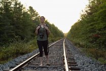Mulher bonita andando em uma trilha ferroviária — Fotografia de Stock