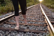Baixa seção de mulher andando em uma trilha ferroviária — Fotografia de Stock