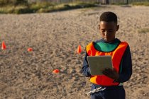 Ребенок с помощью цифровой планшет в земле в солнечный день — стоковое фото