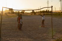 Enfants jouant avec le football dans le sol au crépuscule — Photo de stock