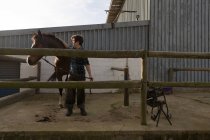 Frau streichelt Pferd an sonnigem Tag im Stall — Stockfoto