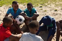 Дети отдыхают в земле после футбола — стоковое фото
